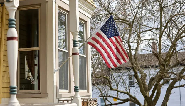 Image of a traditional house flying an American flag.